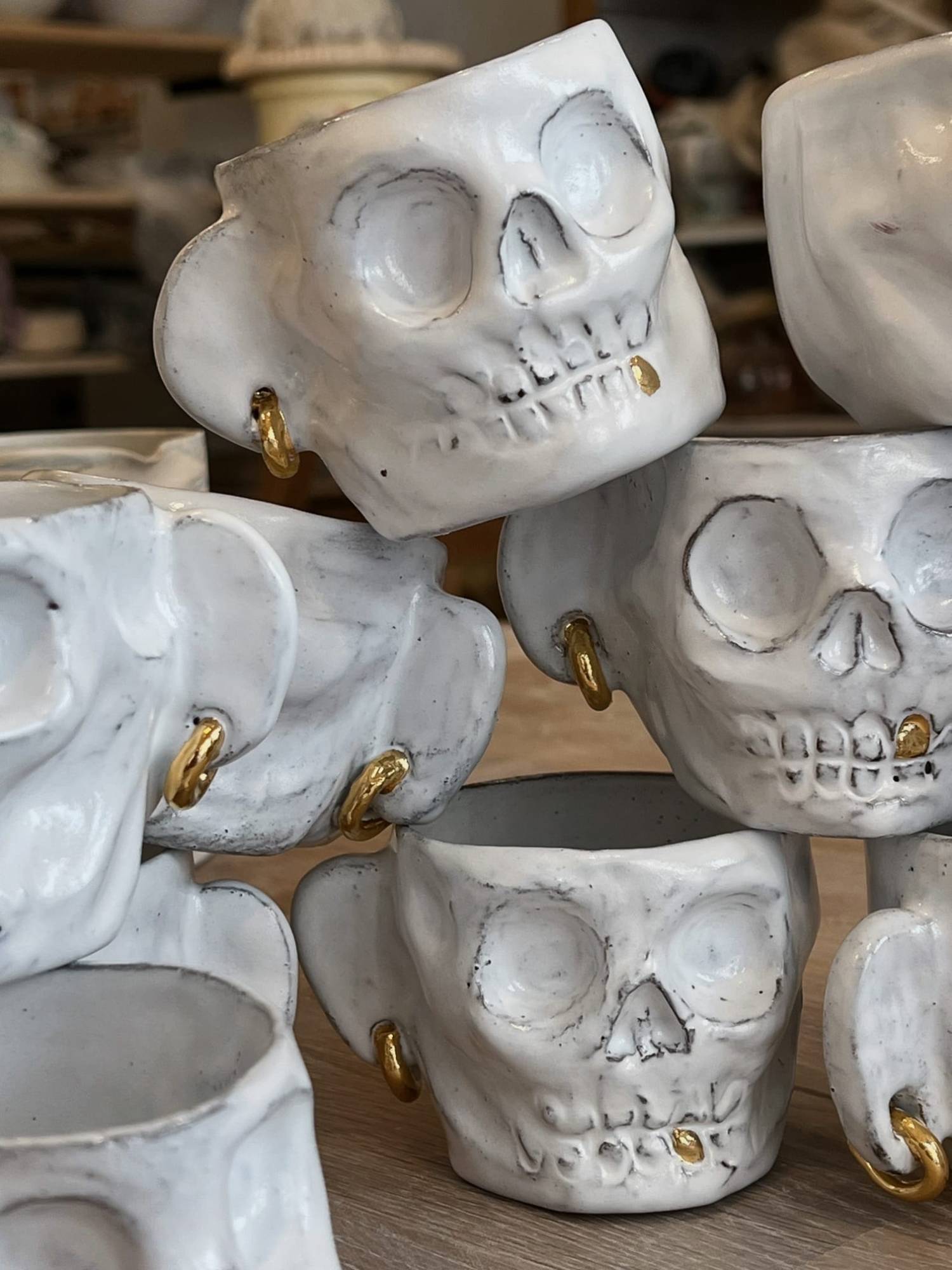 “Skull” earthenware cups, modeled, with gold lustre earrings and teeth