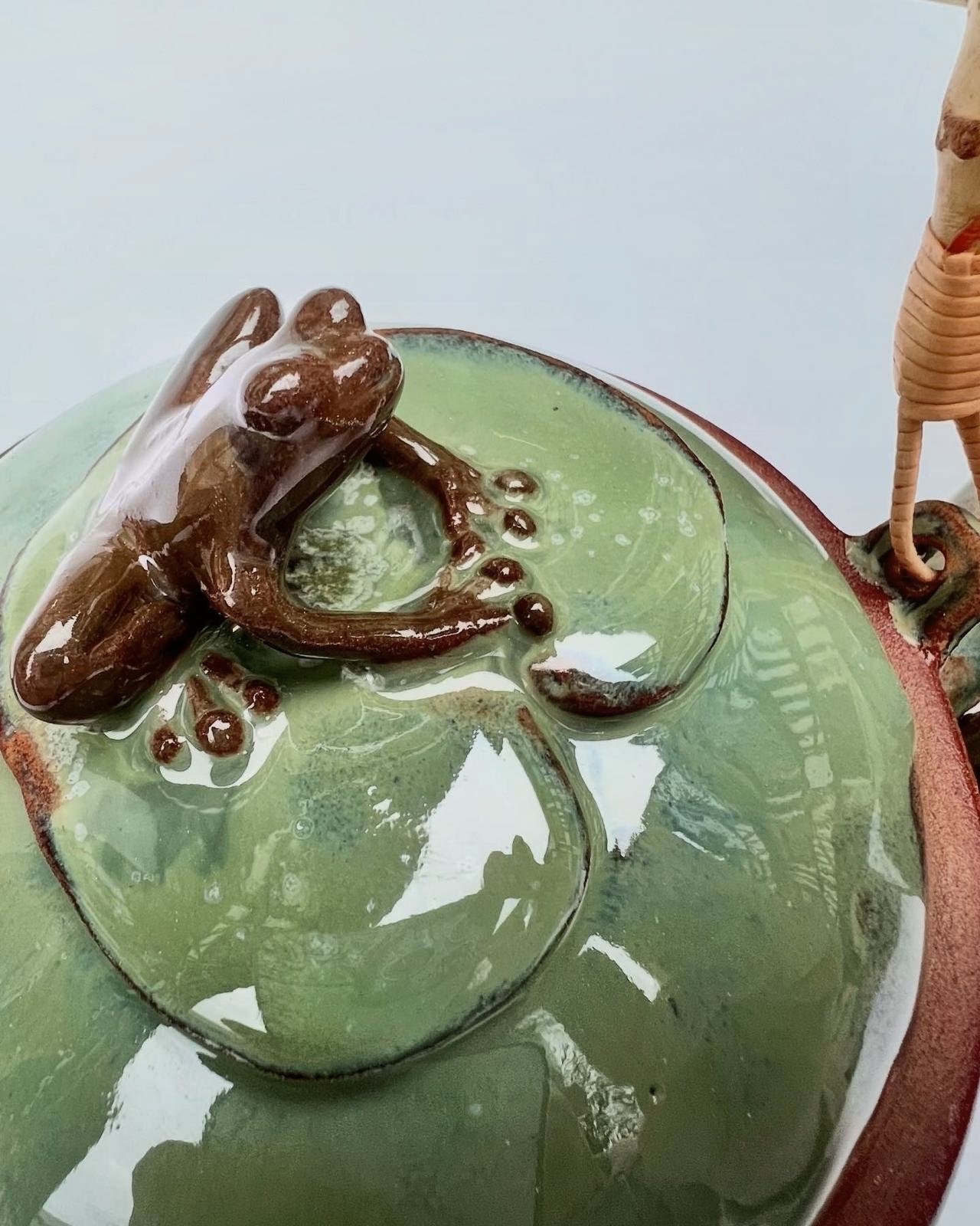 Detail of a teapot, modeled frog on a lily-pad-shaped lid
